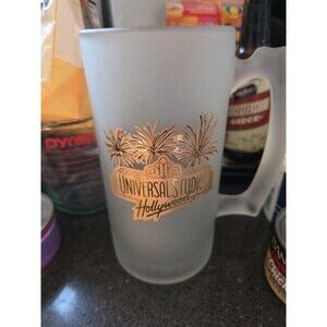 vintage frosted glass Universal Studios Hollywood souvenir mug with a gold logo